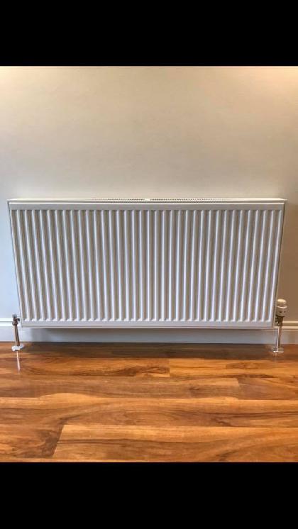 No radiator was previously installed in this livingroom. Ran new pipes under the floor and finished off with a chrome finishing kit, to add a professional finish and to compliment the flooring and decor